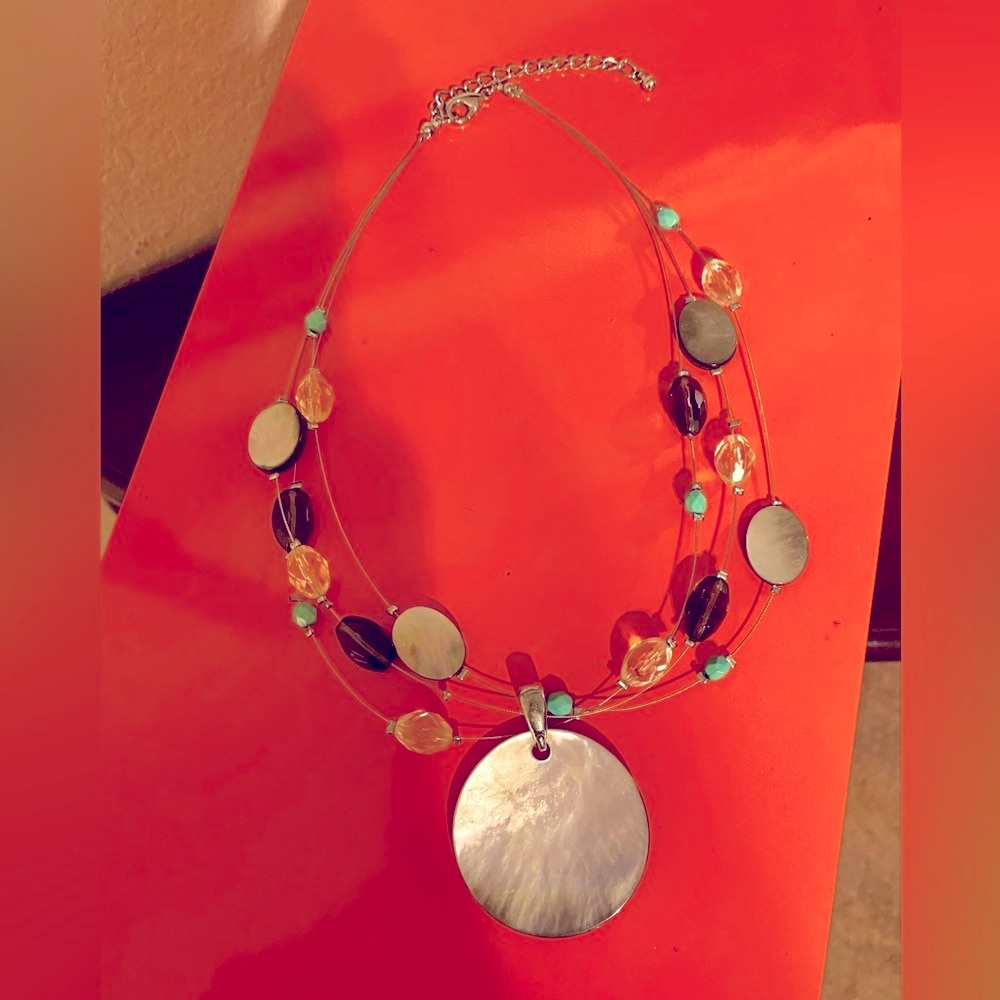 Three stranded multi colored glass beaded necklace with large pendant.
